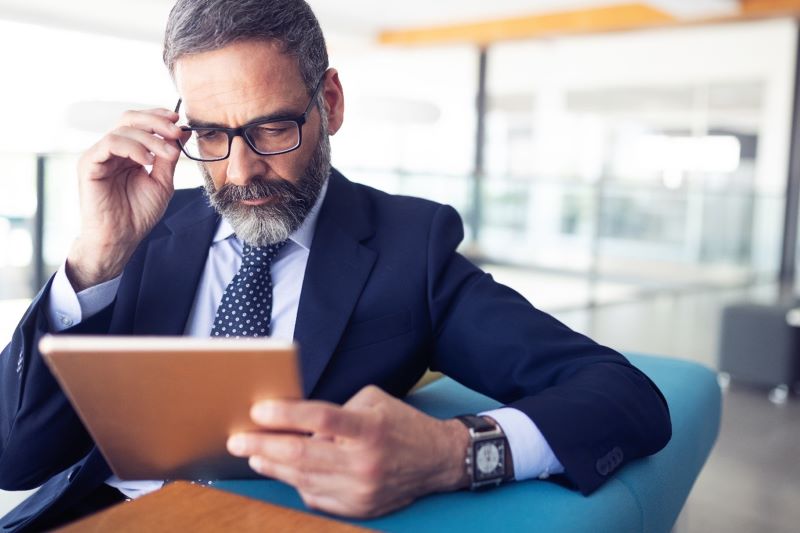 Professional looking at plans & data on a tablet
